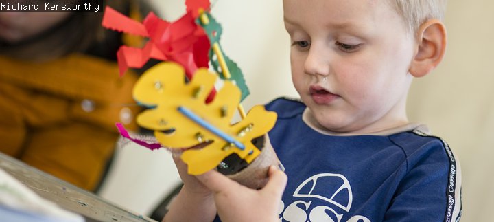 A young boy crafting paper 