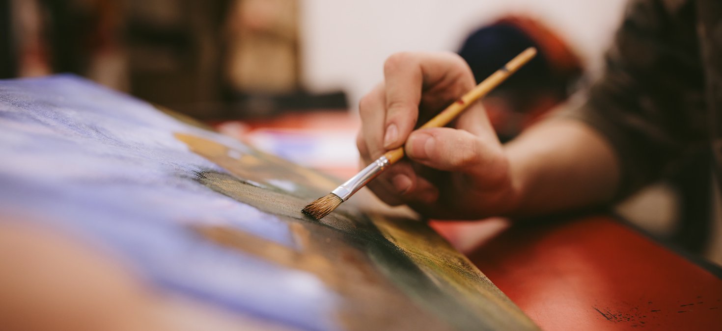 painting by a young boy holding a paintbrush