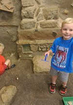 Two boys in Time Quest - 1 is digging and 1 is holding up an object, 