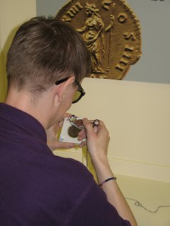 Back view of someone using a loupe to examine an object