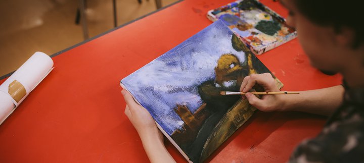 A young person painting on a canvas