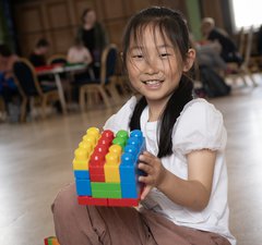 smiling girl holds up her creation 
