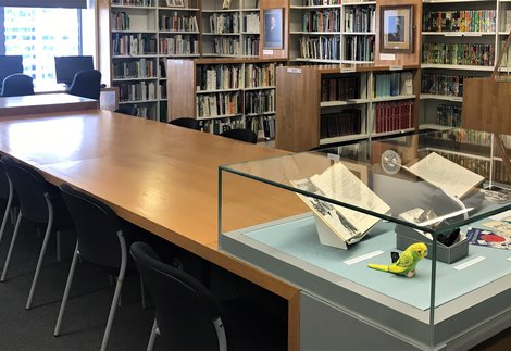 Library shelves, table and case displaying books