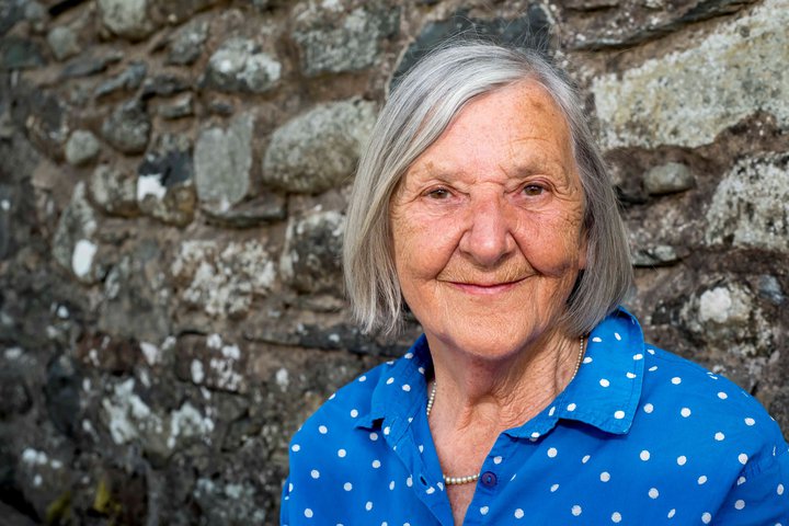 A photograph of a woman wearing a blue and white polka dot shirt.