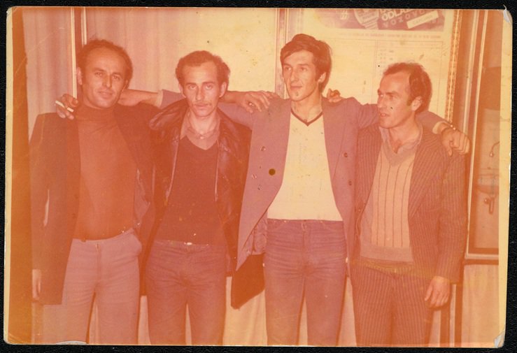 four men in the 1980s with arms on each other's shoulders four men in the 1980s with arms on each other's shoulders