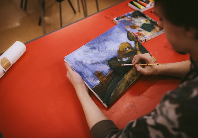 boy painting onto canvas