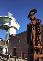 Iron sculpture of Roman soldier with viewing tower in the background