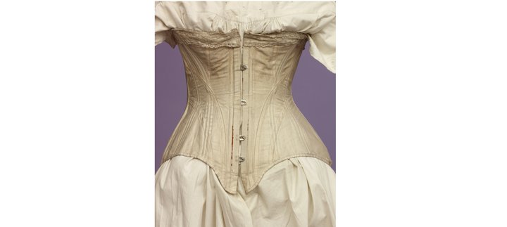 a pale pink Victorian corset on a mannequin