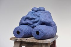 A ceramic sculpture resembling the lower part of a torso is painted blue.