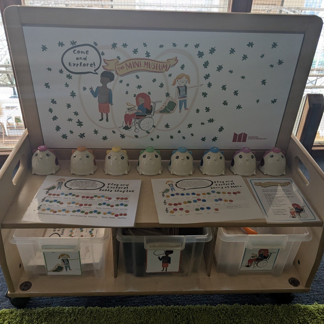 A wooden trolley containing toys and activities.