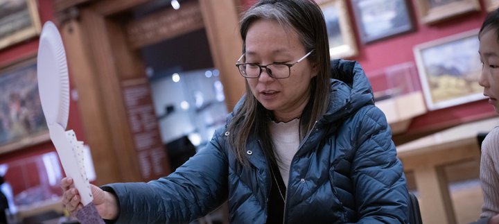 A person sitting at a table and taking part in a creative activity.