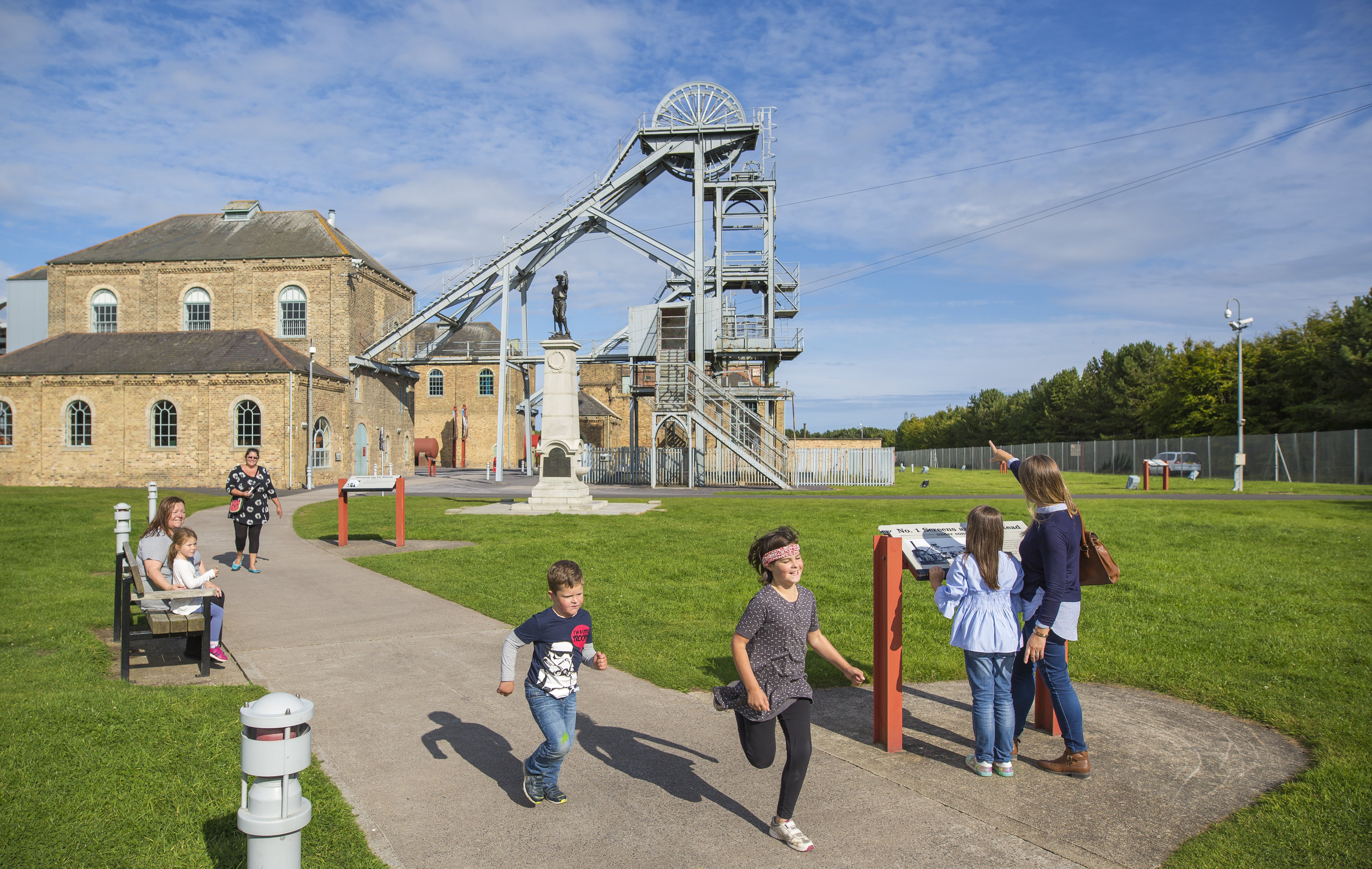 Family groups playing in front of the Colliery buildings at Woodhorn Museum