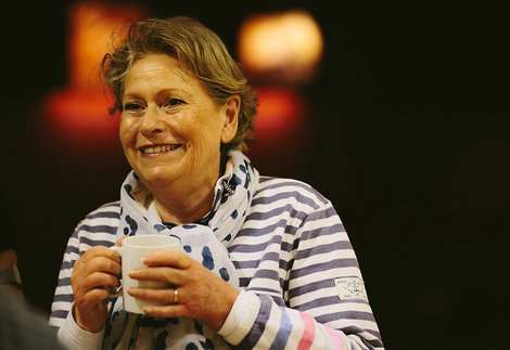 A woman holding a mug with a striped top on