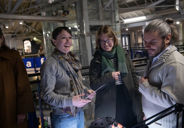 three people smiling in the museum at night