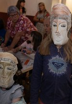 Two children in a Roman museum gallery wearing replica card cavalry masks
