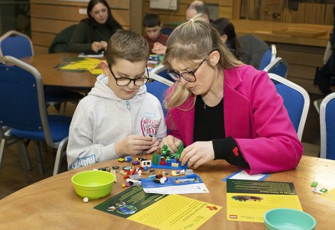 A adult and a child doing a LEGO activity. 