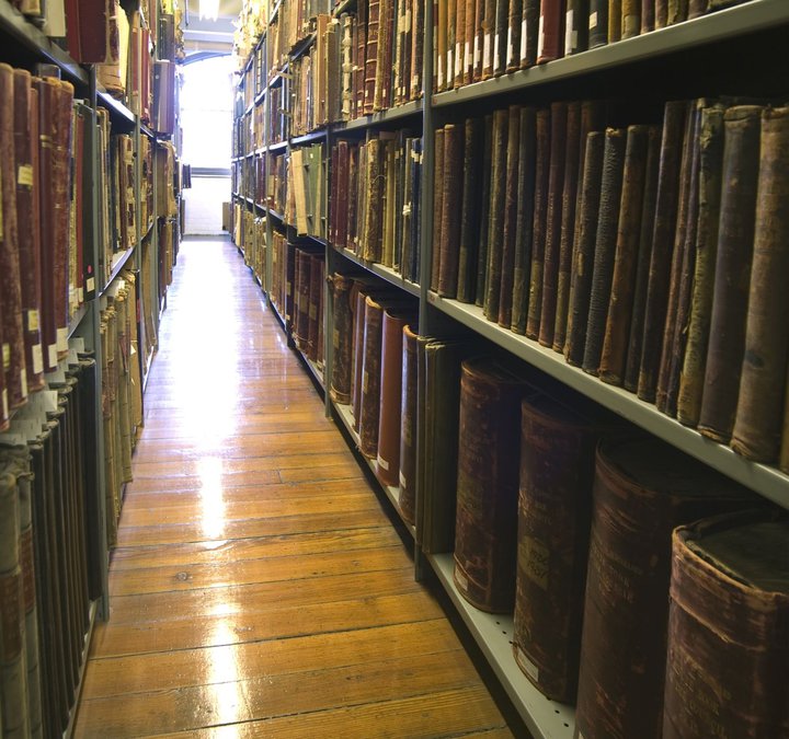 Shelves full of books and papers in the Archives stores