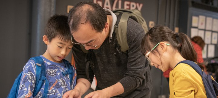 Dad and two children engrossed in craft