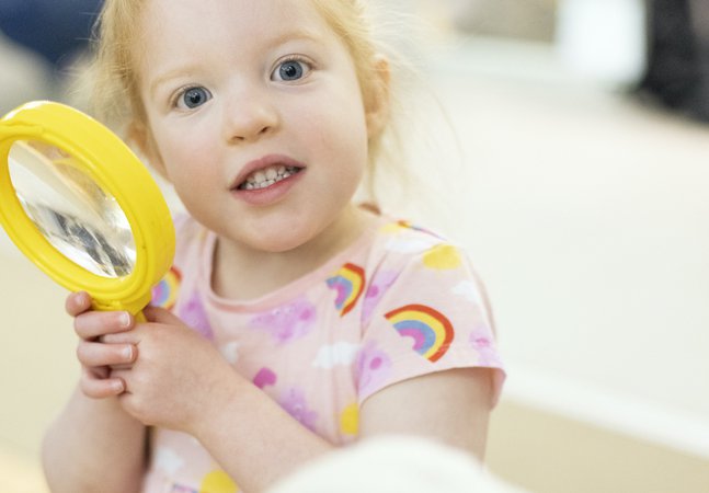 A young girl with a magnifying glass