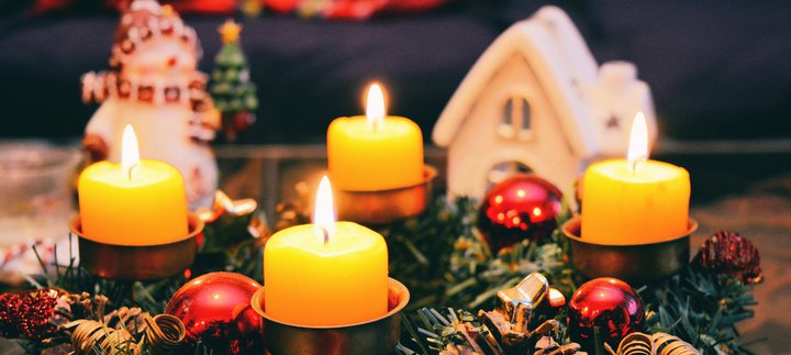 A Christmas table display of greenery and candles.