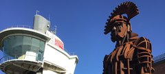 Iron sculpture of Roman soldier with viewing tower in the background