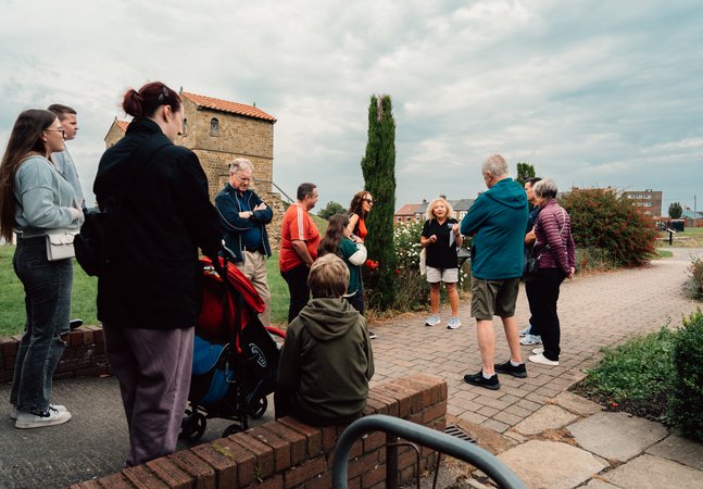 A group of people are gathered around a tour guide
