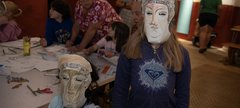 Two children in a Roman museum gallery wearing replica card cavalry masks