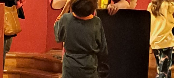 Roman solider holding a spear and shield in Shrine of the Standards talking to a young boy