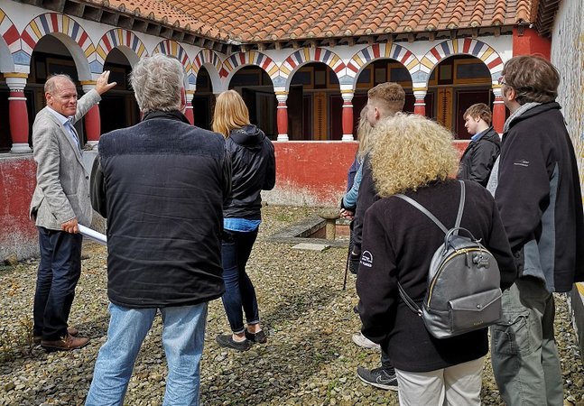 Man talk to group in reconstructed Roman villa 