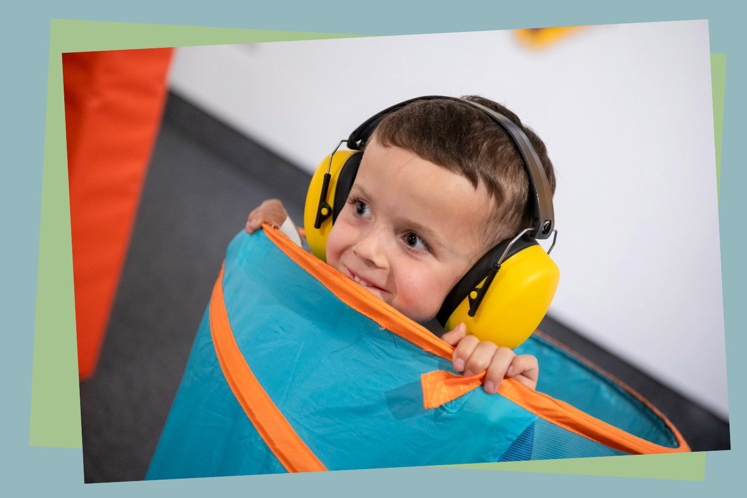 Child wearing ear defenders, playing in a museum.