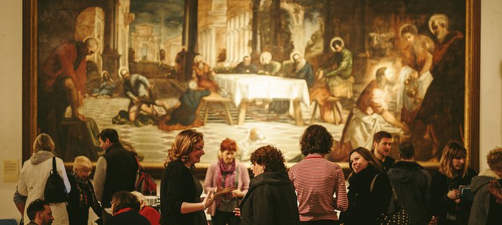 A crowd is gathered around a large painting.
