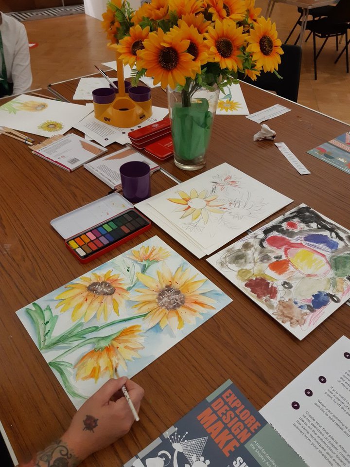 people doing watercolour painting round a table