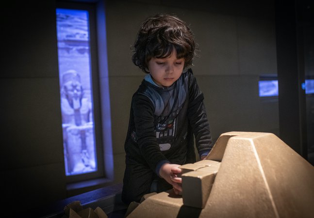 A boy is playing with a children's build a pyramid interactive