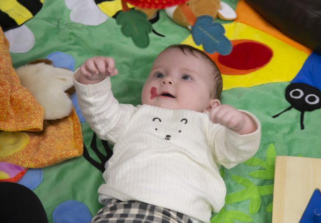 A baby is laying on a sensory mat.