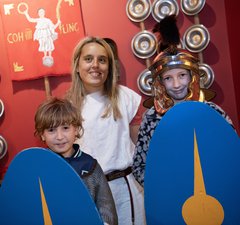 Two young children and an adult dressed as Romans