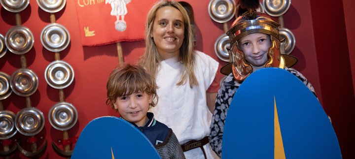 Two young children and an adult dressed as Romans