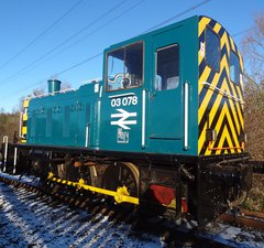 Blue green diesel engine in snow on tracks