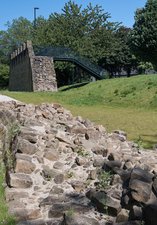 Section of Hadrian's Wall at ground level with Segedunum's viewing tower in the background