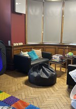 A room with soft furnishings and sensory toys and mats out on a wooden floor 