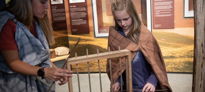 Woman and girl looking at model wattle fence