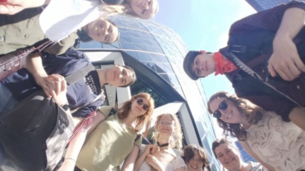 A group of young adults look down at a camera. A group of young adults look down at a camera.