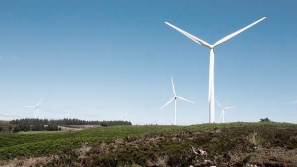Three wind turbines on a hillside against a blue sky Three wind turbines on a hillside against a blue sky