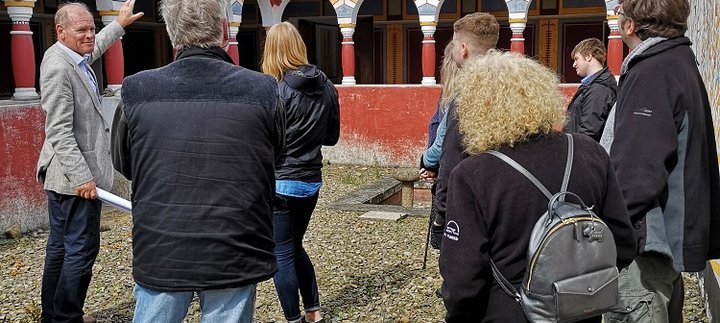 Man talks to group of people in the Roman reconstructions