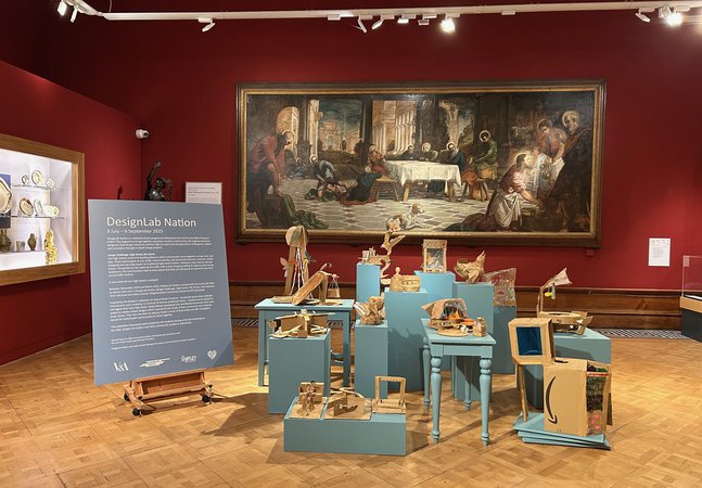 A display of cardboard artwork in a gallery space at the Shipley