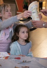 Woman helping to put mask on young girl