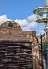 Wooden sign about end of HW trail with viewing tower in the background