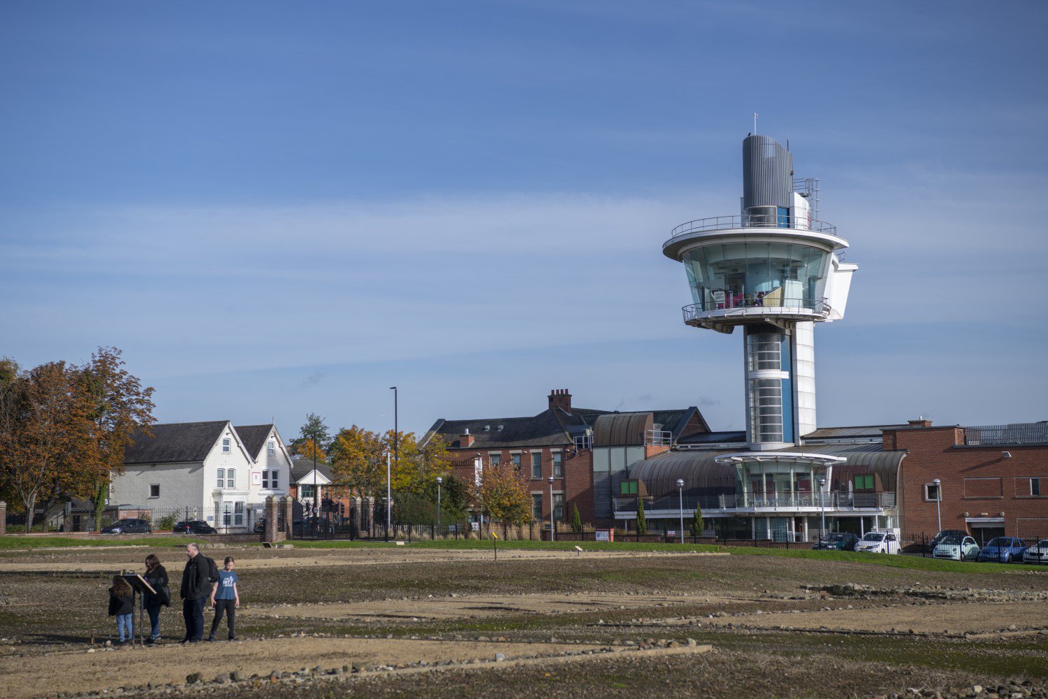 A view of the tower at Segedunum Roman Fort from the fort grounds below. A family are walking on the grounds