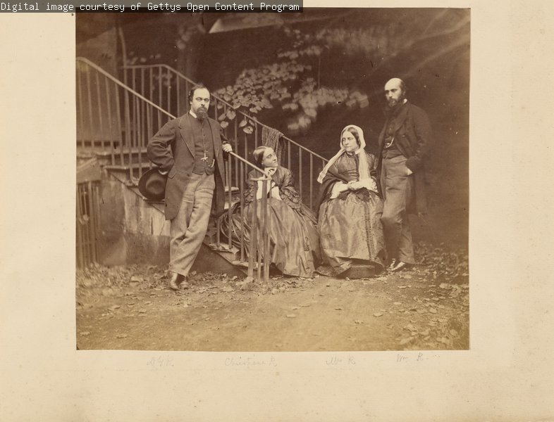 A black and white photograph of Dante Gabriel, Christina, Frances and William Rossetti positioned at the base of an outdoor staircase.