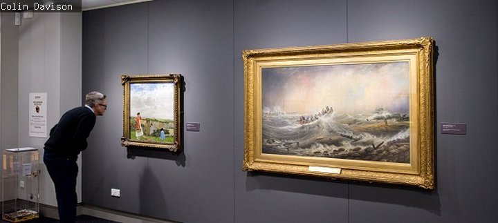 Man looks at a picture in the gallery