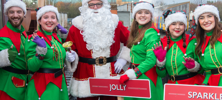 Elves and Santa smiling at the platform at Stephenson Steam Railway